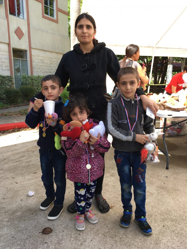 A young refugee mother poses with her children at The Alliance’s spring festival held at the Arab American Cultural and Community Center in Houston. 