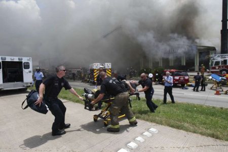 FILE - In this May 31, 2013 file photo, a firefighter injured while fighting a fire at the Southwest Inn in Houston is wheeled to an ambulance. (AP Photo/Houston Chronicle, Cody Duty, File)
