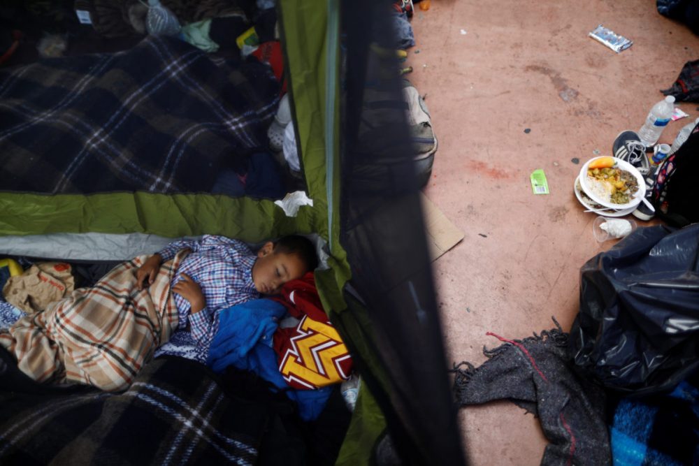 A child traveling with a caravan of migrants from Central America sleeps at a camp near the San Ysidro checkpoint, after U.S. border authorities allowed the first small group of women and children entry from Mexico overnight, in Tijuana, Mexico. 