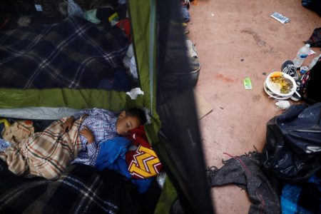 A child traveling with a caravan of migrants from Central America sleeps at a camp near the San Ysidro checkpoint, after U.S. border authorities allowed the first small group of women and children entry from Mexico overnight, in Tijuana, Mexico.