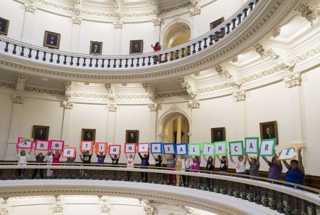 Women holding signs spelling out "abortion = healthcare" line the second floor Capitol rotunda on July 27, 2017, after the House passed a bill requiring more reporting on abortion complications by health care providers.