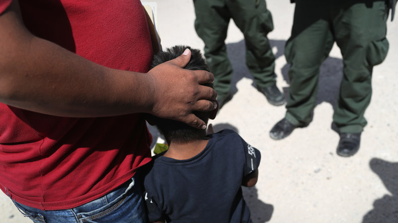 U.S. Border Patrol agents take a father and son from Honduras into custody at the U.S.-Mexico border near Mission, Texas, on Tuesday.
