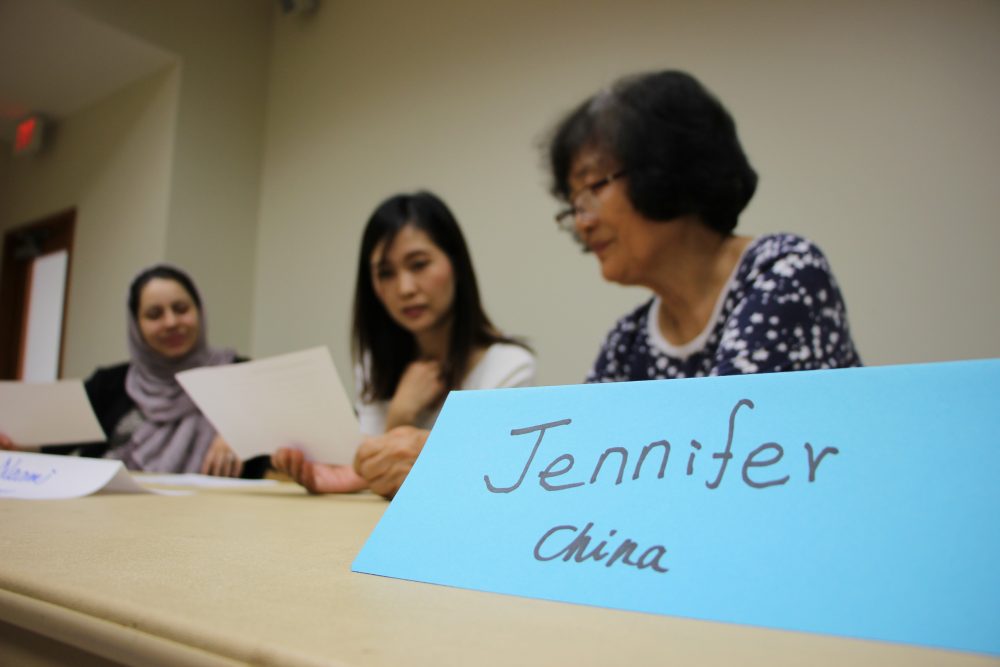 Classmates from Iran, Japan, and China engage in conversation class at the Looscan Neighborhood Library.