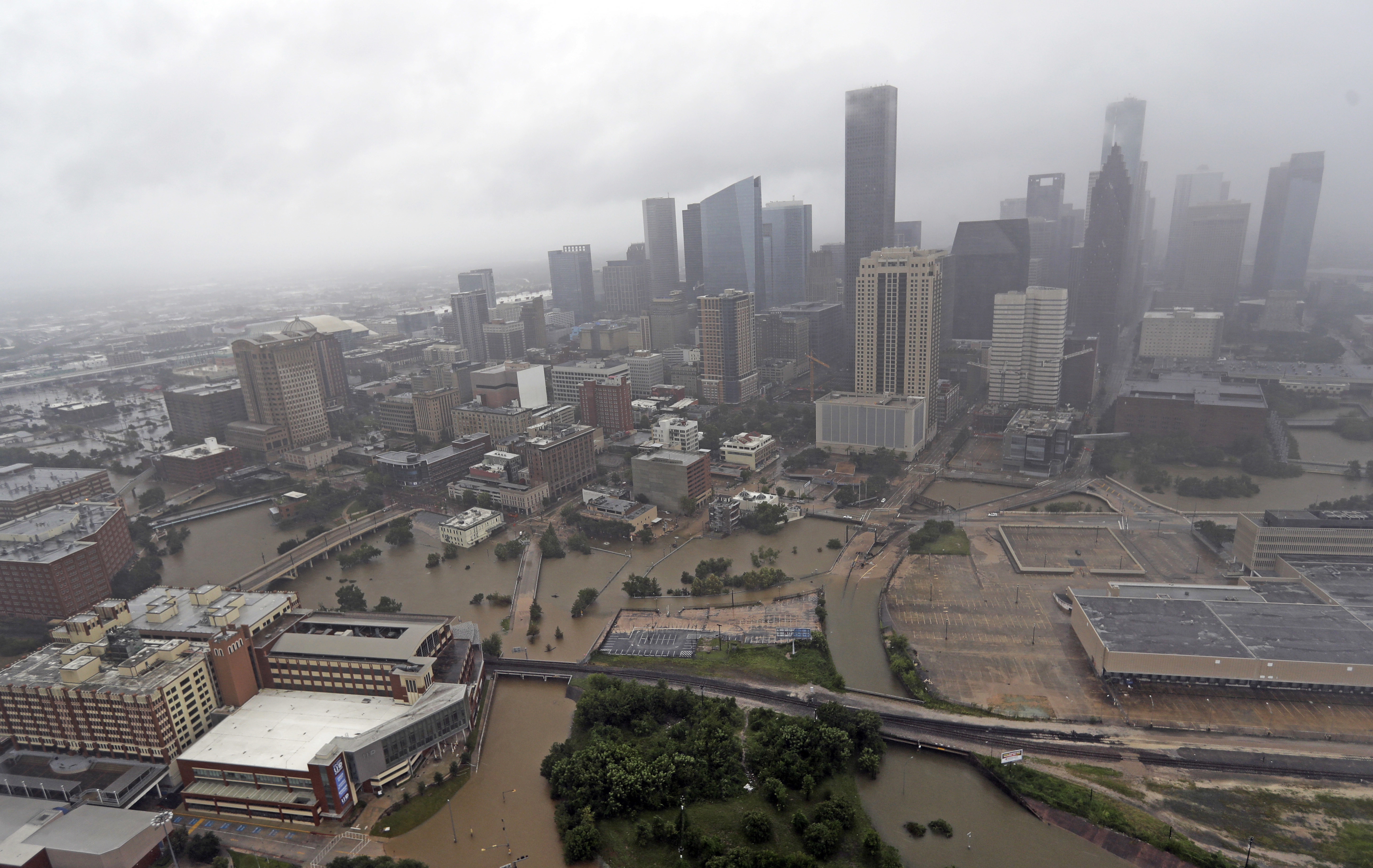 FILE- In this Aug. 29, 2017, file photo, highways around downtown Houston are empty as floodwaters from Tropical Storm Harvey overflow from the bayous around the city in Houston. With three strong hurricanes, wildfires, hail, flooding, tornadoes and drought, supersized weather disasters tallied a record high bill for America last year: $306 billion. (AP Photo/David J. Phillip, File)