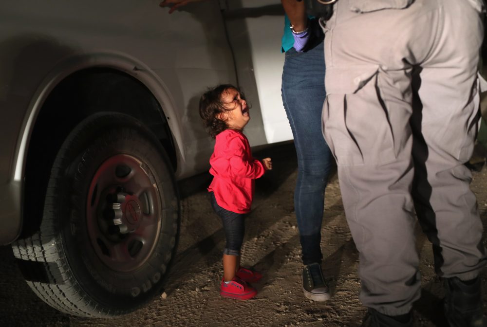 A 2-year-old Honduran girl cries as an official searches her mother near the U.S.-Mexico border earlier this month in McAllen, Texas. For many, the image has become indelibly associated with a Trump administration policy that for weeks separated migrant children from their parents — but the girl's father says she was not separated from her mother.
