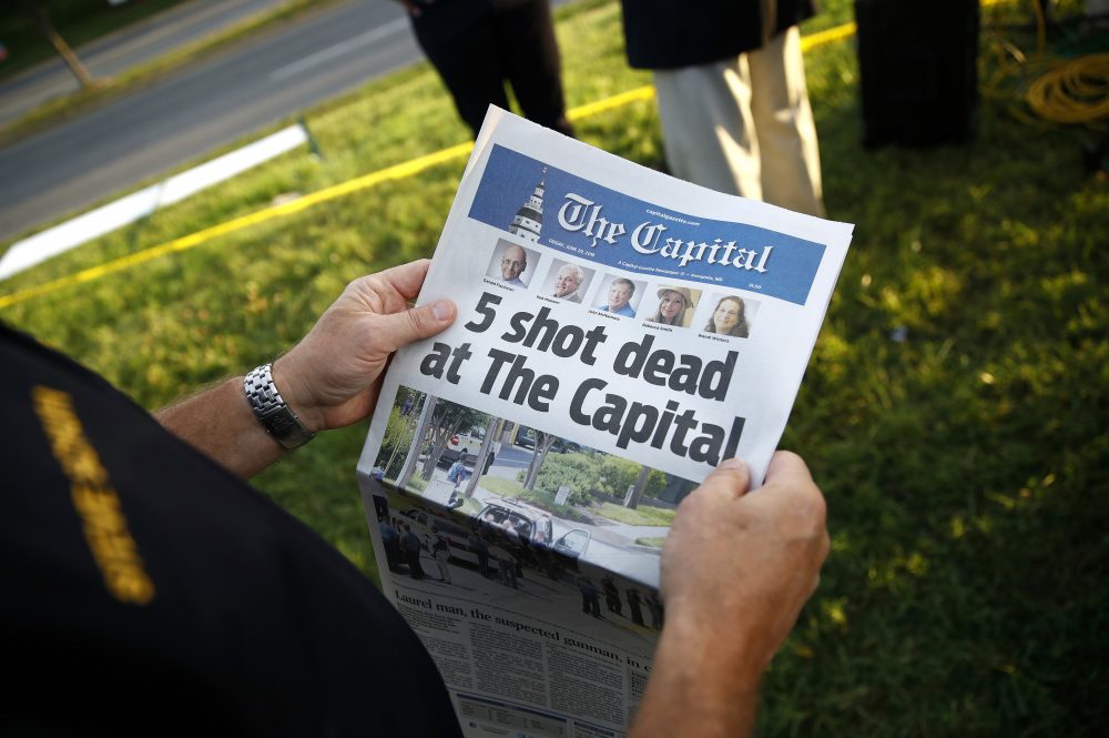 Steve Schuh, county executive of Anne Arundel County, holds a copy of The Capital Gazette near the scene of a shooting at the newspaper's office, Friday, June 29, 2018, in Annapolis, Md. A man armed with smoke grenades and a shotgun attacked journalists in the building Thursday, killing several people before police quickly stormed the building and arrested him, police and witnesses said. (AP Photo/Patrick Semansky)