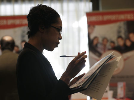 Joana Dudley looks at a list of job prospects at a job fair in Miami Lakes, Fla., in January. Economists say the government's June jobs report is likely to show a continued tightening of the labor market.
