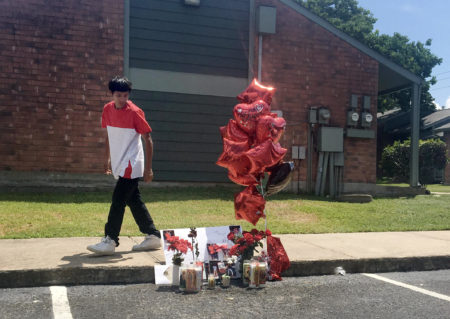 A boy walks by a memorial for Devonte Ortiz, who was killed in the parking lot of the Pleasant Hill Apartments in Southeast Austin on Wednesday. The suspect in the case said he acted in self-defense.