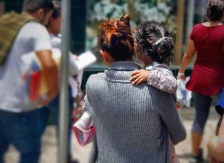 A mother carrying her child in McAllen, Texas, after being released from detention in June, 2018.