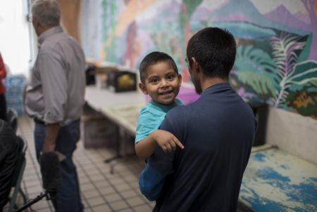 Pablo Ortiz and his 3-year-old Andres, both from Guatemala, walk into the common area of the Annunciation House in El Paso on Wednesday, July 11, 2018. Ortiz and his son were separated by ICE in April and were reunited and released late Tuesday night.