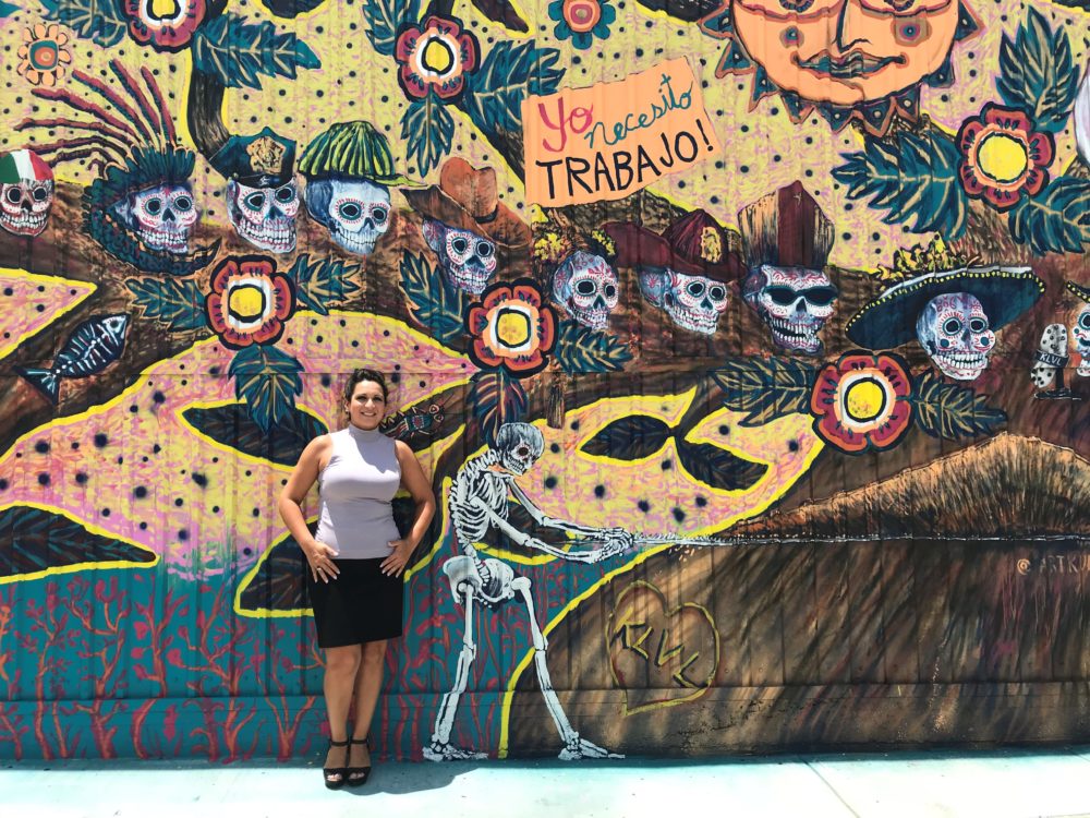 Christina Morales stands in front of the new mural at the Morales Radio Hall in Houston's East End