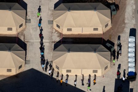 Immigrant children are led by staff in single file between tents at a detention facility next to the Mexican border in Tornillo on June 18, 2018.