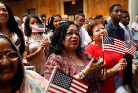 New citizens stand during a U.S. Citizenship and Immigration Services (USCIS) naturalization ceremony at the New York Public Library in Manhattan, New York, U.S., July 3, 2018.