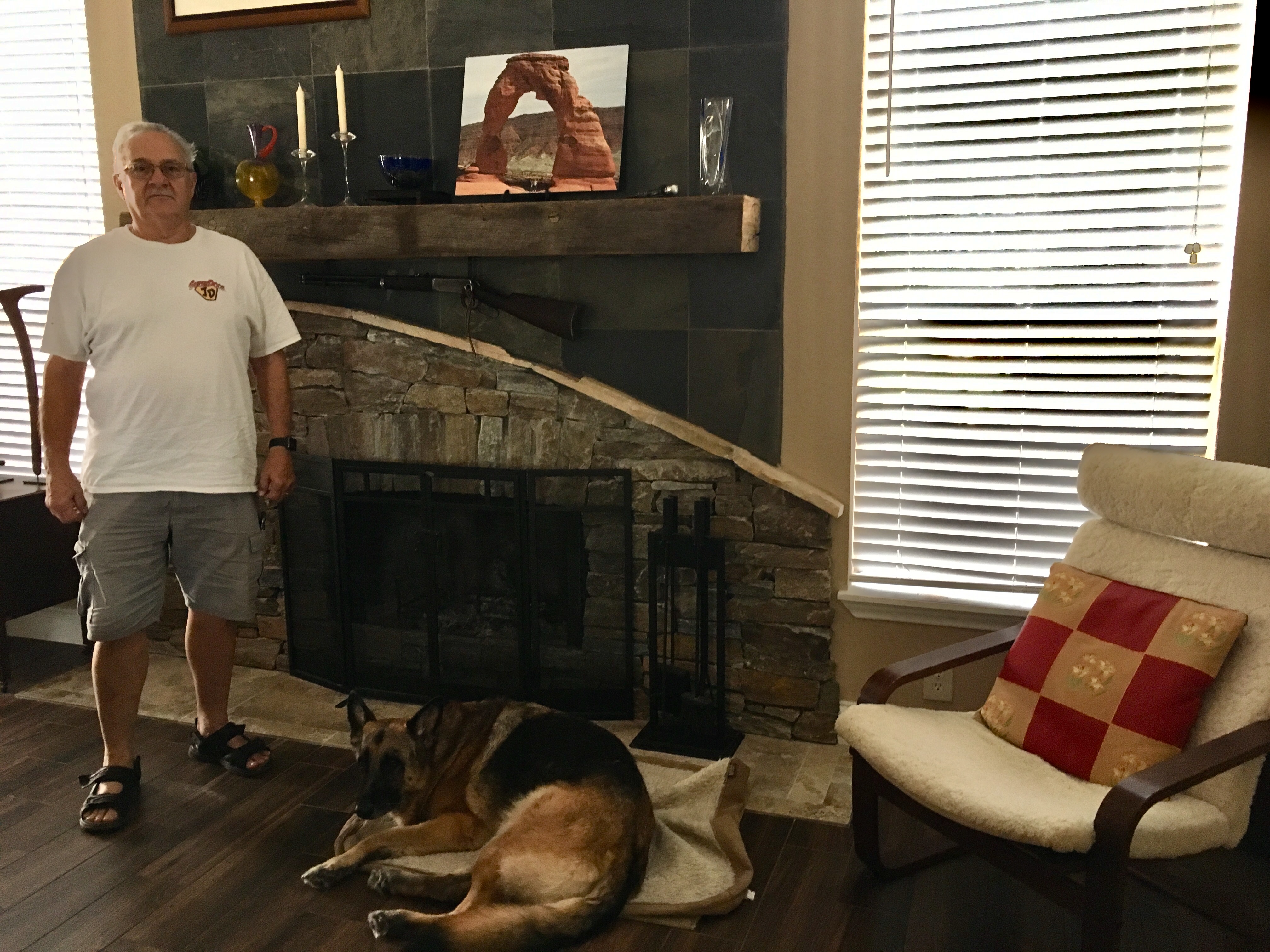 Jim Pongrass and his dog Bailey, pictured in front of the new fireplace he built after Harvey flooded his home.