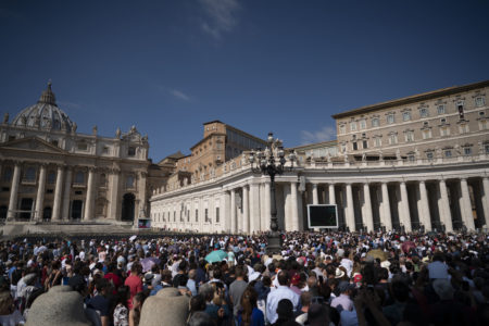 People gather in St. Peter's Square at the Vatican as Pope Francis recites the Angelus noon prayer from the window of his studio, top right, Sunday, Sept. 30, 2018. (AP Photo/Andrew Medichini)