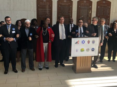 Rabbi David Lyon and other Houston area religious leaders join arms to symbolize the diversity in their unity against polarizing language.
