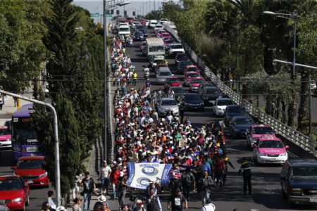 A group of Central American migrants, representing the thousands participating in a caravan trying to reach the U.S. border, undertake an hours-long march to the office of the United Nations' humans rights body in Mexico City, Thursday, Nov. 8, 2018. Members of the caravan which has stopped in Mexico City demanded buses Thursday to take them to the U.S. border, saying it is too cold and dangerous to continue walking and hitchhiking.
