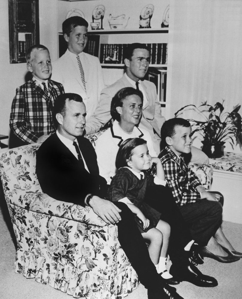 George H.W. Bush sits on couch with his wife Barbara  and their children in 1964.  George W Bush sits at right behind his mother.  Behind couch are Neil and Jeb Bush. Sitting with parents are Dorothy and Marvin Bush.  
