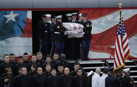 The flag-draped casket of former President George H.W. Bush is carried by a joint services military honor guard after it arrived by train, Thursday, Dec. 6, 2018, in College Station. (AP Photo/Eric Gay)