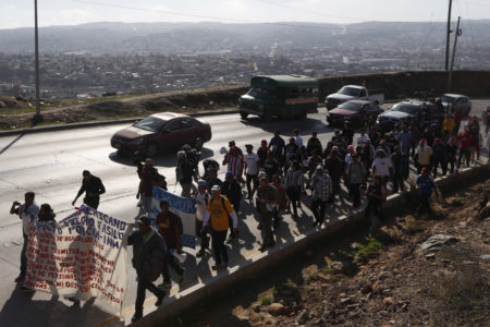 Central American migrants march to the U.S. consulate in Tijuana, Mexico, Tuesday, Dec. 11, 2018. Migrants want U.S. authorities to speed up the asylum application process for members of migrant caravans seeking to enter the U.S., including accepting more applications per day. (AP Photo/Moises Castillo)