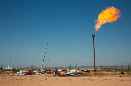 A flare burns on May 24, 2018, atop a drill pad on land near Carlsbad. The oil-rich Permian Basin straddles West Texas and southeastern New Mexico.
