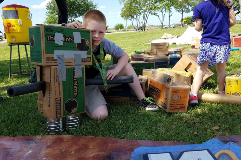 A boy and the robot he made from boxes