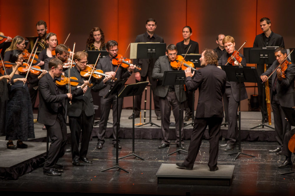 Concert photo of orchestra musicians and conductor