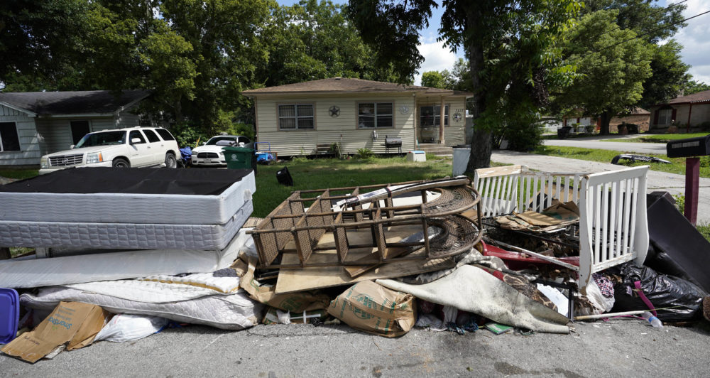 In this Aug. 9, 2018 photo, recently removed flood-damaged debris sits outside a home in Houston. Hurricane Harvey has been described as the storm that did not discriminate, damaging neighborhoods both rich and poor. But community and grassroots leaders say that a year after the storm, those having the hardest time recovering are residents who live in some of the poorest areas hit hardest by Harvey. (AP Photo/David J. Phillip)