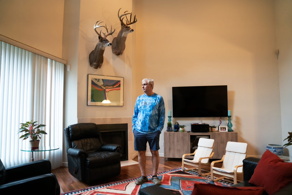 John Papadopoulos stands in the rental home in Houston where he and his family moved after their house flooded. The taxidermied deer are among the few items they were able to rescue from their flooded home.