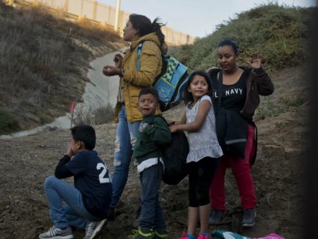 Honduran migrants surrender to the U.S. Border Patrol after crossing a border wall into the United States. According to new federal data, the number of migrants apprehended crossing the border in recent months has surged.