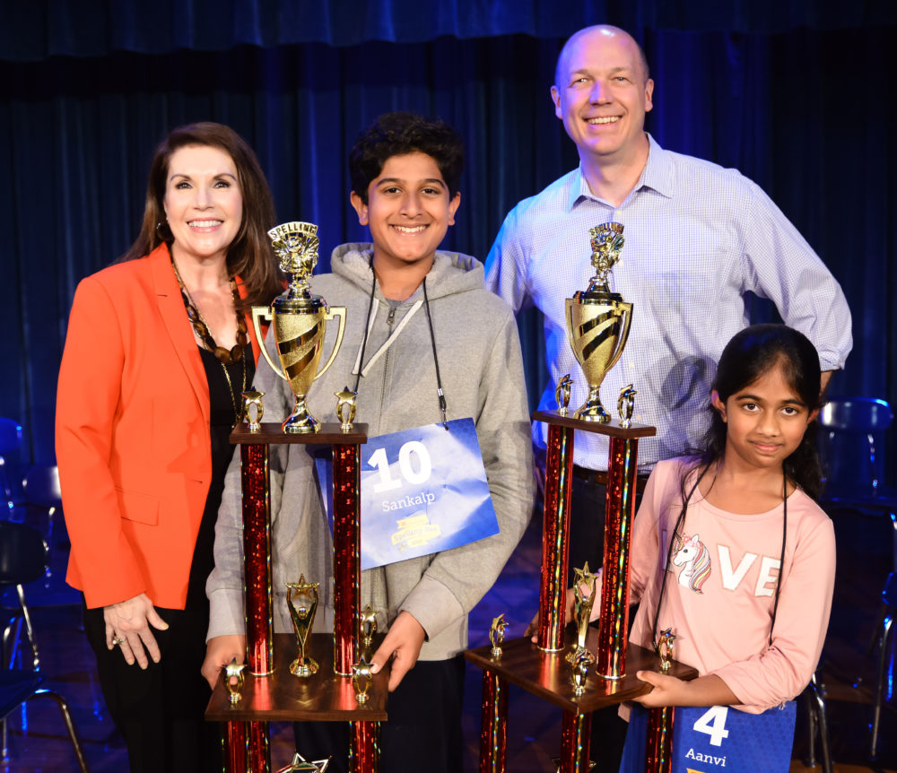 2019 HPM Spelling Bee winner Aanvi Manda (right) and runner-up Sankalp Gautam (left), with HPM's Vice-President and General Manager, Lisa Shumate, and Executive Director of Operations, Josh Adams.