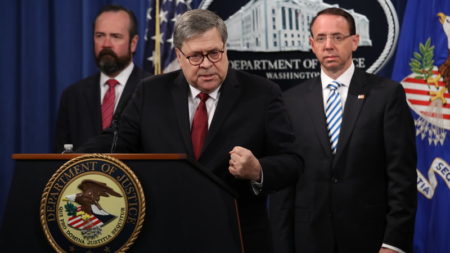Attorney General William Barr speaks about the release of the redacted version of the Mueller report as U.S. Deputy Attorney General Rod Rosenstein, right, and U.S. Acting Principal Associate Deputy Attorney General Ed O'Callaghan listen at the Department of Justice Thursday in Washington, D.C.