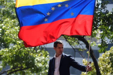 Venezuelan opposition leader and self-proclaimed acting president Juan Guaido is pictured under a national flag during a gathering with supporters after members of the Bolivarian National Guard joined his campaign to oust President Nicolas Maduro, in Caracas on April 30.