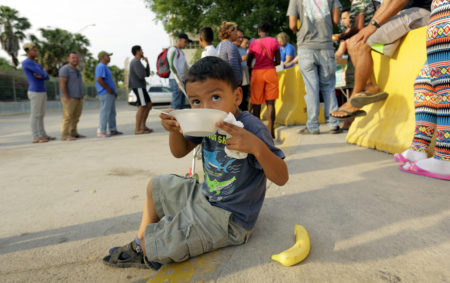 William Linares, 5, who is traveling with his mother Suanny Gomez from Honduras and seeking asylum in the United States eats breakfast provided by volunteers, Tuesday, April 30, 2019, in Matamoros, Mexico. Gomez said she does not have money to pay a proposed fee for seeking asylum.
