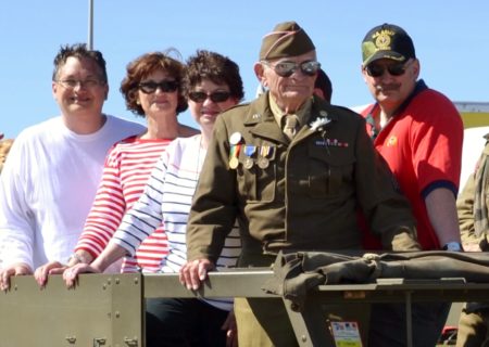 Ret. Technical Sergeant John Trippon, a combat engineer who landed with the second wave of troops on Omaha Beach Normandy rides in the Omaha Beach parade with his family in France at the 75th anniversary of the D-Day invasion. (May 29, 2019)