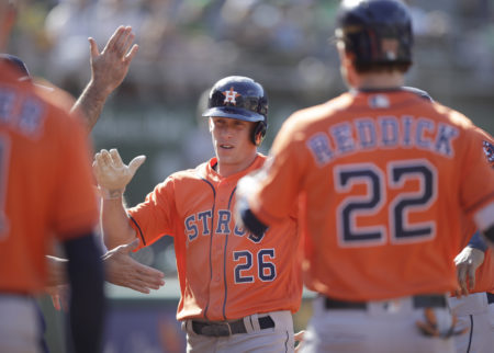 Houston Astros' Myles Straw (26) celebrates after scoring against the Oakland Athletics in the 12th inning of a baseball game Sunday, June 2, 2019, in Oakland, Calif.
