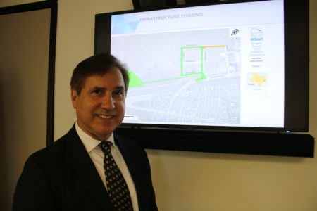 Arturo Machuca, general manager of Ellington Airport and the Houston Spaceport, stands in front of a blueprint of Phase 1 of spaceport construction at Ellington.