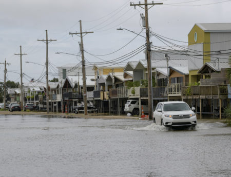 An SUV travels down Breakwater Drive in New Orleans, La., Friday, July 12, 2019, near the Orleans Marina as water moves in from Lake Pontchartrain from the storm surge from Tropical Storm Barry in the Gulf of Mexico. The area is behind a flood wall that protects the rest of the city.