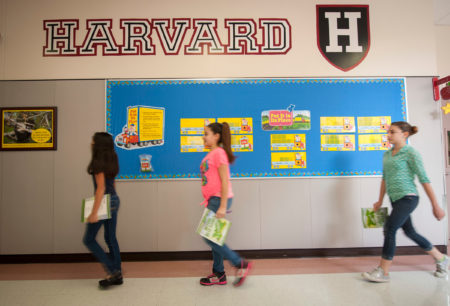 Students at Lyons Elementary school pass by logos for major universities on their way to lunch in this archive photo.