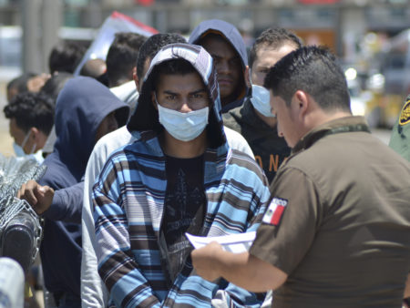 U.S. Border Patrol officers return a group of asylum-seeking migrants to Mexico as Mexican officials check the list, in Nuevo Laredo.