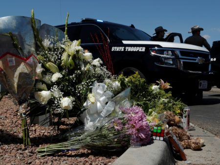 Flowers adorn a makeshift memorial near the scene of a mass shooting at a shopping complex Sunday in El Paso, Texas.