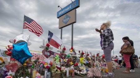 A woman prays at a makeshift memorial for shooting victims at the Cielo Vista Mall Walmart, in El Paso, Texas.