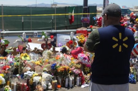 A Walmart employee from a nearby store visits a memorial outside the store where the shooting happened.