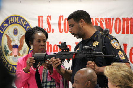 A sergeant with the Harris County Sheriff's Office shows Rep. Sheila Jackson Lee, D-Houston, an assault weapon seized by law enforcement.
