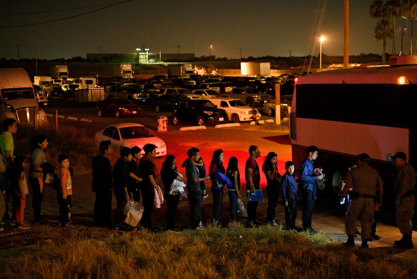 Migrant families who turned themselves in to U.S. Border Patrol to seek asylum after illegally crossing the Rio Grande are loaded onto a transport bus in Hidalgo on Aug. 23, 2019.