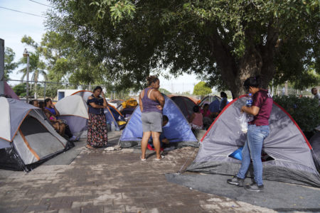 Asylum seekers pass their time in encampment on Friday, Aug. 30, 2019, near the Gateway International Bridge in Matamoros, Mexico.