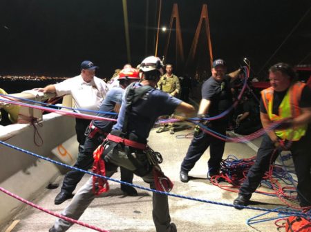 Firefighters lower one of the Greenpeace protesters who were dangling from the Fred Hartman Bridge, near Baytown, on Thursday, Sept. 12, 2019. The activists wanted to challenge the ten Democratic candidates participating in Houston’s presidential debate to hold the fossil fuel industry accountable if they won the election in 2020.