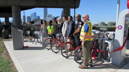 Dignitaries gather for a ribbon-cutting for the new BCycle station at the Burnett Transit Center.