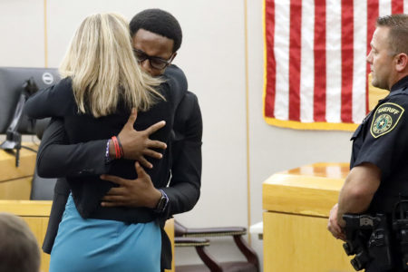 Botham Jean's younger brother Brandt Jean hugs convicted murderer and former Dallas Police Officer Amber Guyger after delivering his impact statement to her after she was sentenced to 10 years in jail.