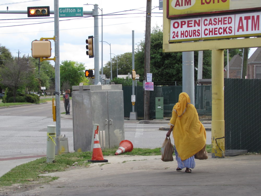A pedestrian prepares to cross the street in Gulfton